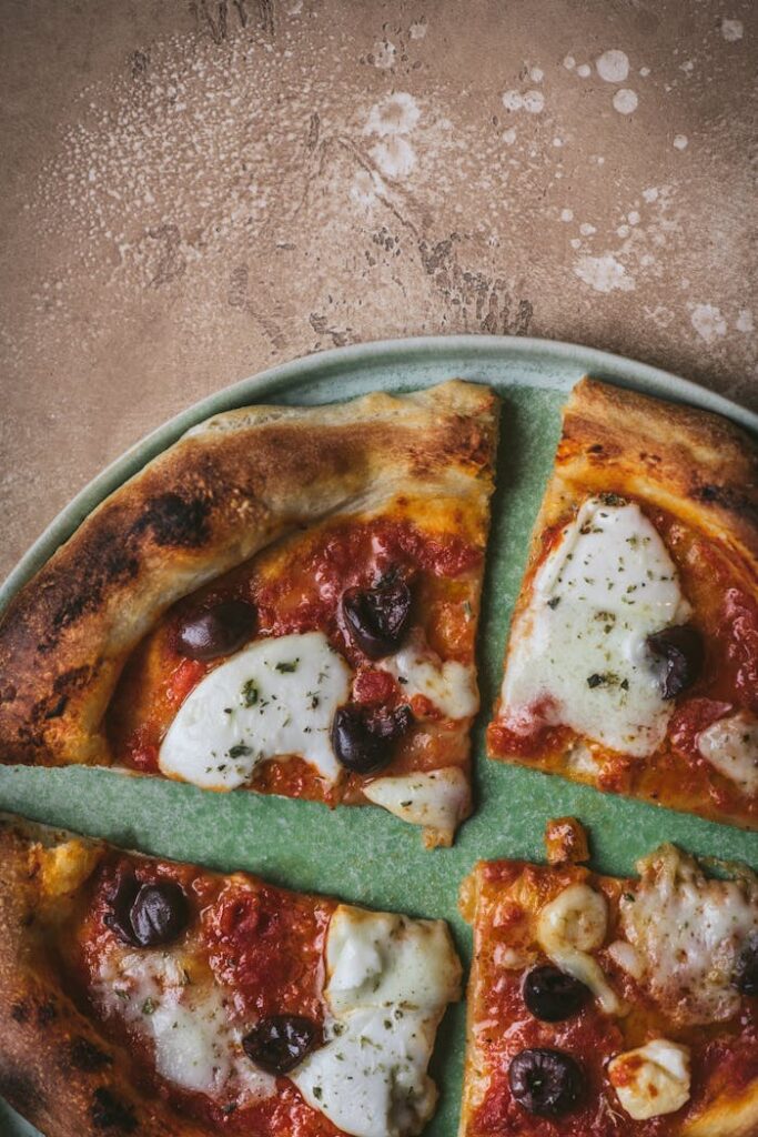 pexels-photo-11136515 Appetizing view of a freshly baked Italian pizza with olives and mozzarella, perfect for a gourmet meal.