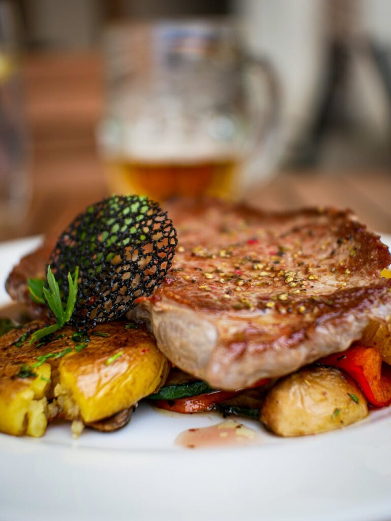 pexels-photo-4886680-4886680 Close-up of a delicious grilled steak served with roasted vegetables on a gourmet plate.